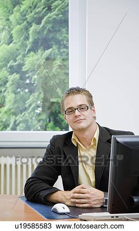 Portrait of man on computer in office View Large Photo Image Stock Image - Portrait of man on computer in office. Fotosearch