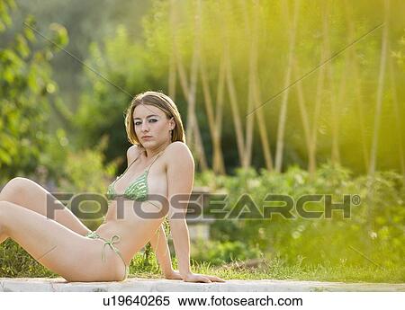 Portrait of woman relaxing by the pool View Large Photo Image Stock Photography - Portrait of woman relaxing by the pool. Fotosearch