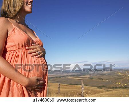 Stock Photo - Pregnant woman contemplating view. Fotosearch