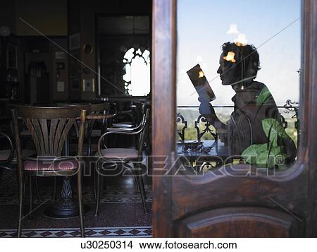 Reflection of man reading in café. View Large Photo Image Picture - Reflection of man reading in café.. Fotosearch