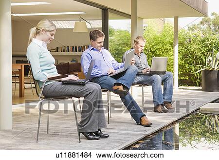 Three business associates at work. View Large Photo Image Picture - Three business associates at work.. Fotosearch
