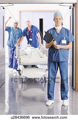 Three doctors pushing a patient in bed View Large Photo Image Stock Photograph - Three doctors pushing a patient in bed. Fotosearch