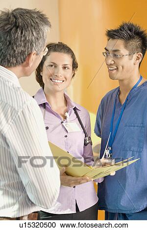 Stock Image - Three medical colleagues talking. Fotosearch