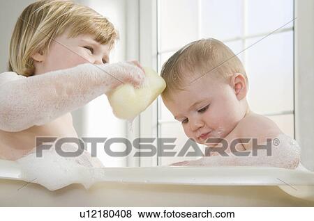 Stock Photo - Two baby sisters in the bath.. Fotosearch
