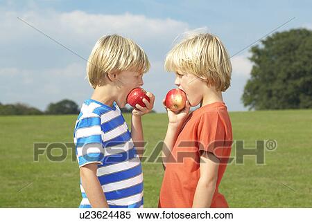 Stock Photography - two boy eating apples. Fotosearch