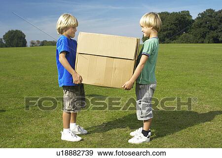 Stock Photo - two boys holding box. Fotosearch