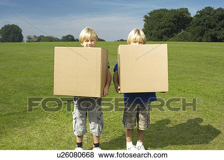 Stock Photo - two boys holding boxes. Fotosearch