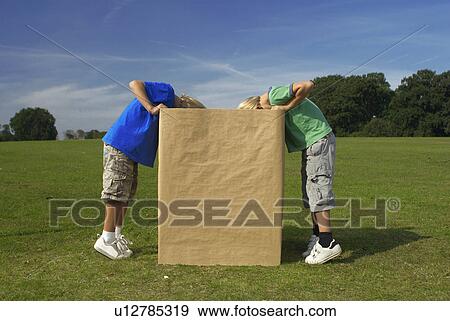 Stock Photo - two boys looking into box. Fotosearch