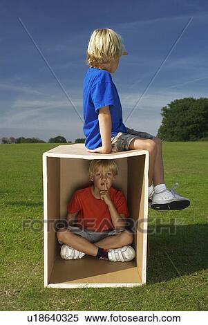 Stock Photography - two boys playing with box. Fotosearch