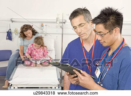 Two doctors check a patient notes View Large Photo Image Stock Photo - Two doctors check a patient notes. Fotosearch