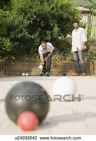 Stock Image - Two men playing bocce ball. Fotosearch