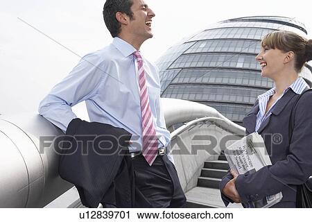 Stock Image - Two office workers outside talking. Fotosearch