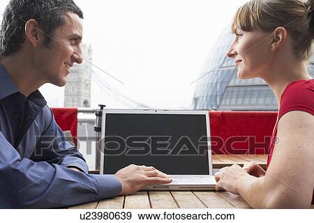 Stock Photo - Two office workers outside with laptop. Fotosearch