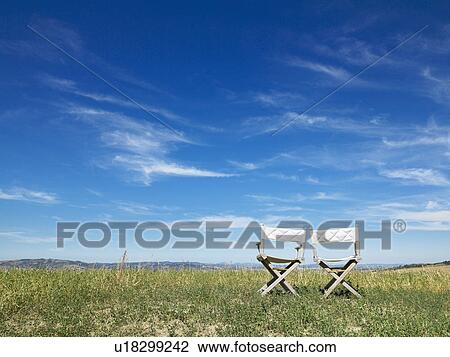 Stock Image - Two seats in front of landscape. Fotosearch