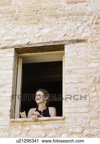 Woman and a cat looking out a window View Large Photo Image Stock Image - Woman and a cat looking out a window. Fotosearch