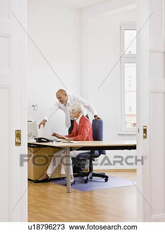 Woman and man working on computer View Large Photo Image Stock Image - Woman and man working on computer. Fotosearch