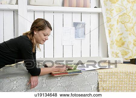 Stock Photo - Woman choosing fabrics. Fotosearch