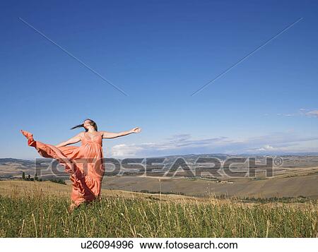 Stock Photograph - Woman dancing in field. Fotosearch
