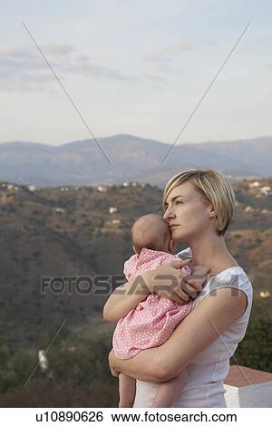 Stock Photograph - Woman holding baby. Fotosearch