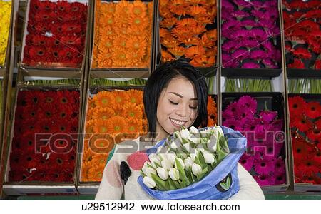 Stock Image - Woman holding bunch of flowers. Fotosearch