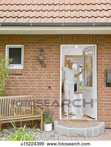 Stock Photo - Woman in the doorway of a home. Fotosearch