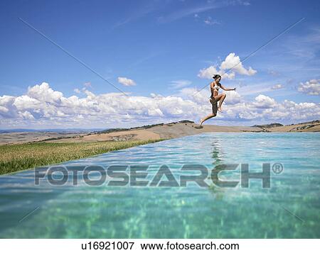 Woman jumping in swimming pool View Large Photo Image Stock Photo - Woman jumping in swimming pool. Fotosearch