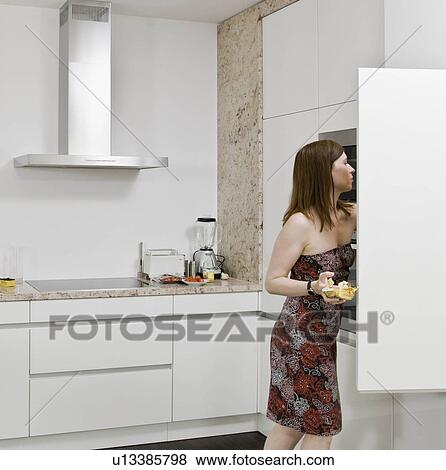 Woman looking for food in the cupboards View Large Photo Image Stock Photo - Woman looking for food in the cupboards. Fotosearch