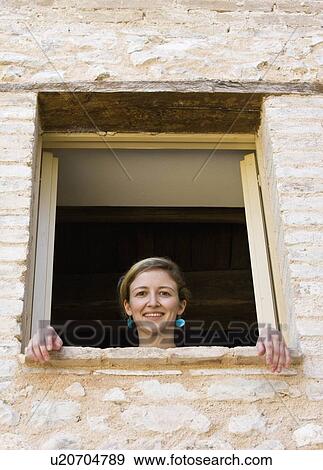 Woman looking out a window View Large Photo Image Stock Photo - Woman looking out a window. Fotosearch