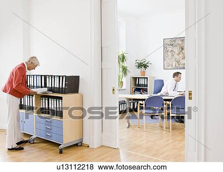 Woman looking through files View Large Photo Image Stock Photo - Woman looking through files. Fotosearch