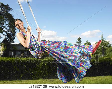 Stock Photo - Woman on a swing, blue sky above. Fotosearch