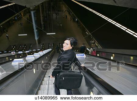 Stock Photography - Woman on escalator. Fotosearch