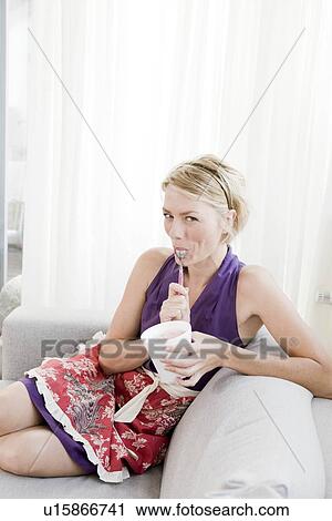 Woman on sofa eating ice cream View Large Photo Image Stock Image - Woman on sofa eating ice cream. Fotosearch