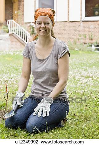 Stock Image - Woman planting a garden. Fotosearch