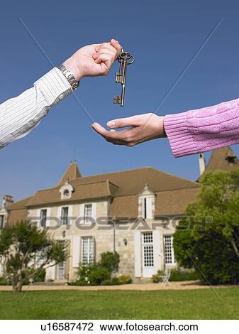 Stock Image - Woman receiving keys to country home. Fotosearch