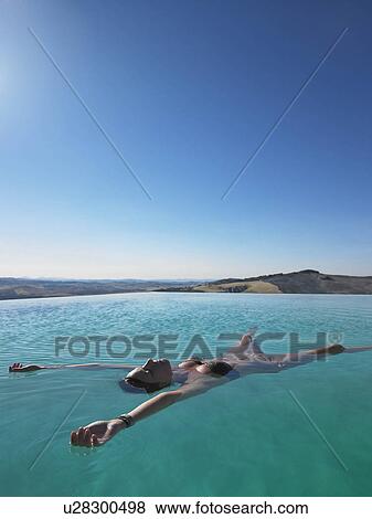 Stock Photo - Woman resting in swimming pool. Fotosearch