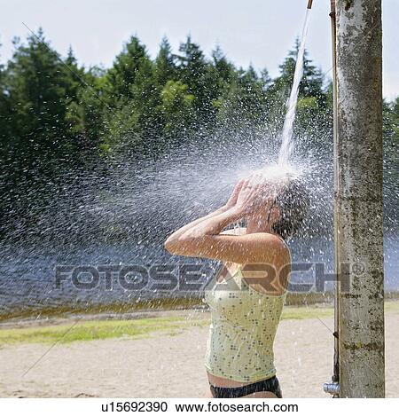 Stock Image - Woman showering outdoors. Fotosearch