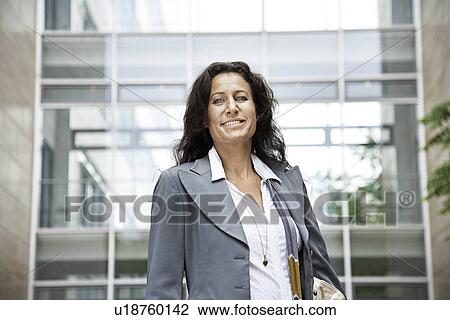 Stock Image - Woman standing in front of building. Fotosearch