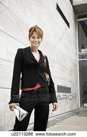 Stock Photograph - Woman standing in front of building. Fotosearch