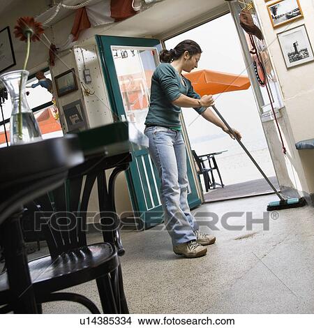 Picture - Woman sweeping in a cafe. Fotosearch