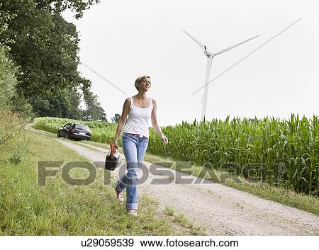 Woman walking with a gas can View Large Photo Image Stock Photo - Woman walking with a gas can. Fotosearch