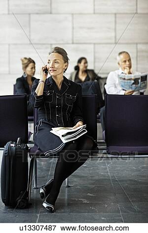 Stock Photo - Woman with a suitcase, on the phone. Fotosearch
