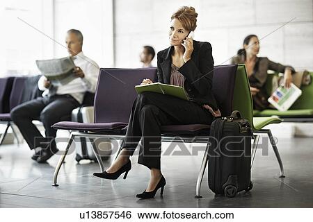 Stock Photograph - Woman with suitcase, on the phone. Fotosearch