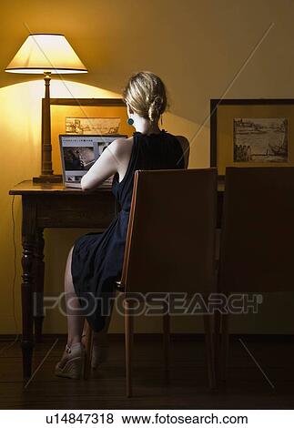 Stock Photo - Woman working on a laptop computer. Fotosearch