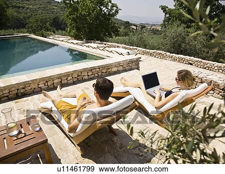 Woman working on computer by the pool View Large Photo Image Stock Photo - Woman working on computer by the pool. Fotosearch