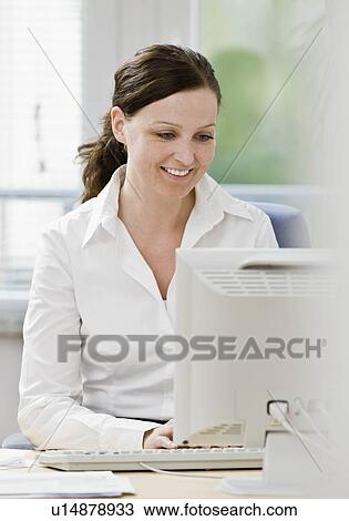 Stock Image - Woman working on computer. Fotosearch