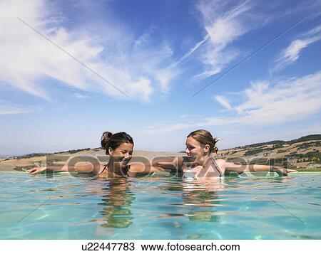 Stock Image - women gossiping in swimming pool. Fotosearch