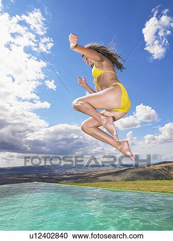 Women jumping in swimming pool View Large Photo Image Stock Image - Women jumping in swimming pool. Fotosearch