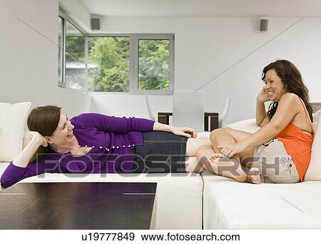 Women laying on the couch talking View Large Photo Image Stock Photo - Women laying on the couch talking. Fotosearch