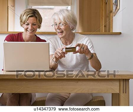 Stock Photo - Women shopping on computer. Fotosearch