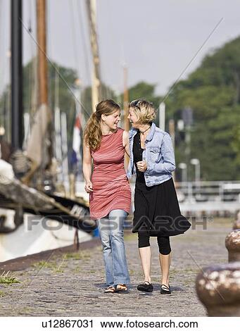 Women walking on a pier View Large Photo Image Stock Image - Women walking on a pier. Fotosearch